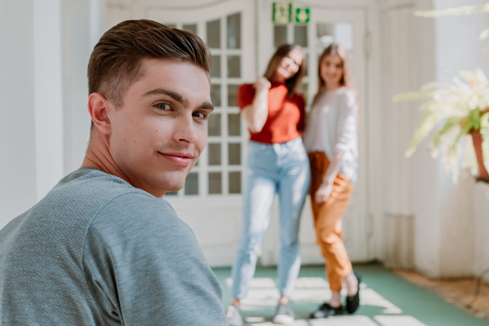 One guy in the front of the photo and two girls in the background