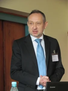 A man with a black suit and a blue tie